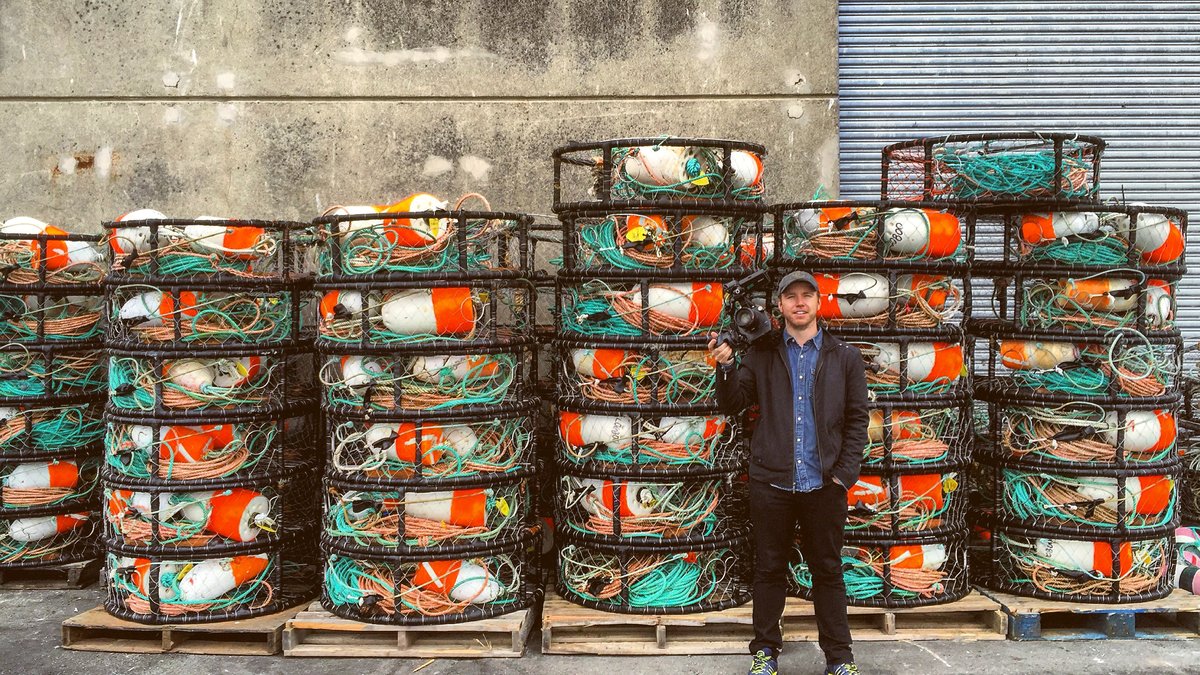Documentary — director beside stacked crab pots on the working waterfront